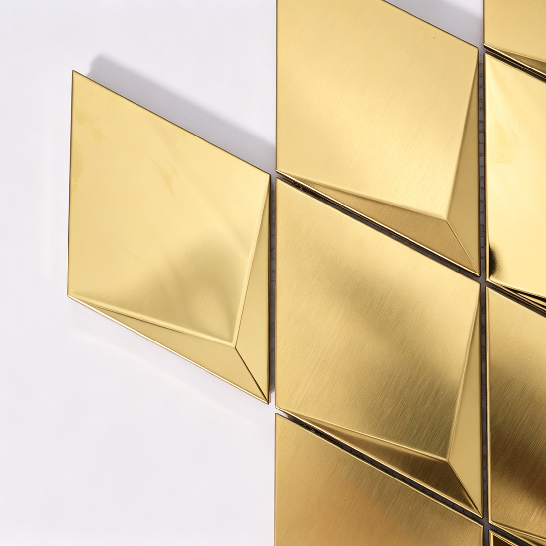 Corner detail of gold geometric metal mosaic tiles