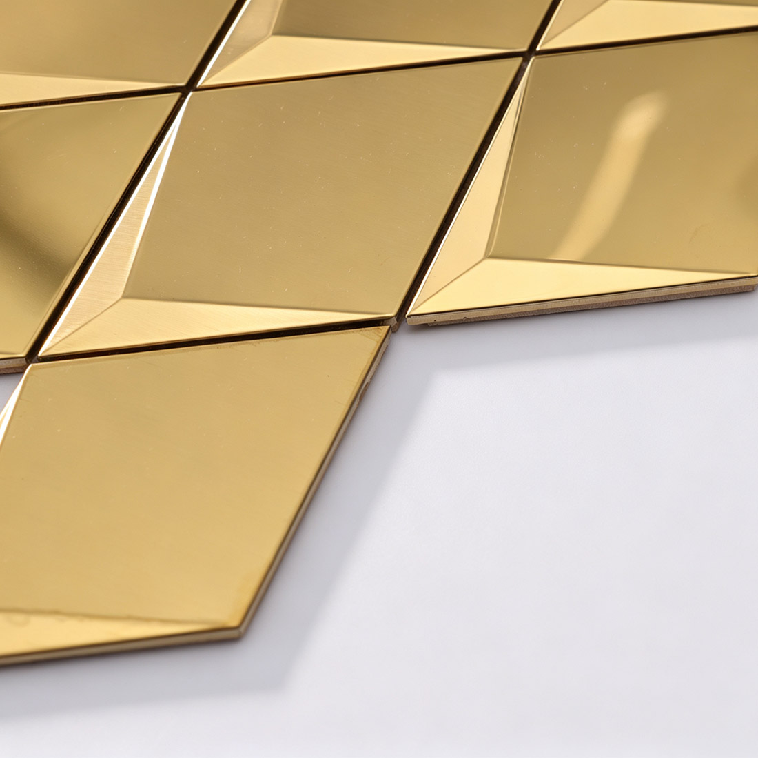 Angled view of gold geometric metal mosaic tile sheet edge