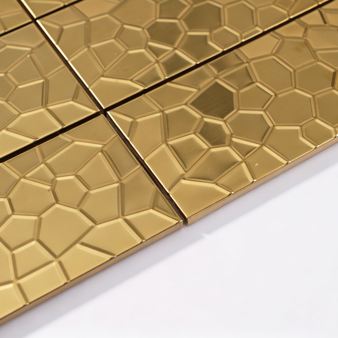 Angled view of gold geometric rectangle metal tile sheet edge