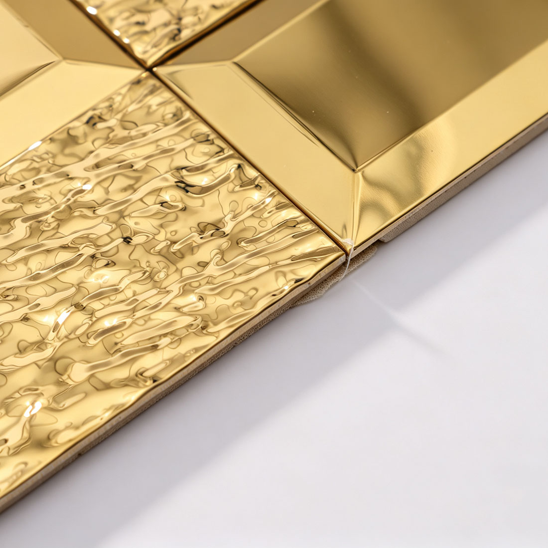 Angled view of gold hammered rectangle metal mosaic tile sheet edge