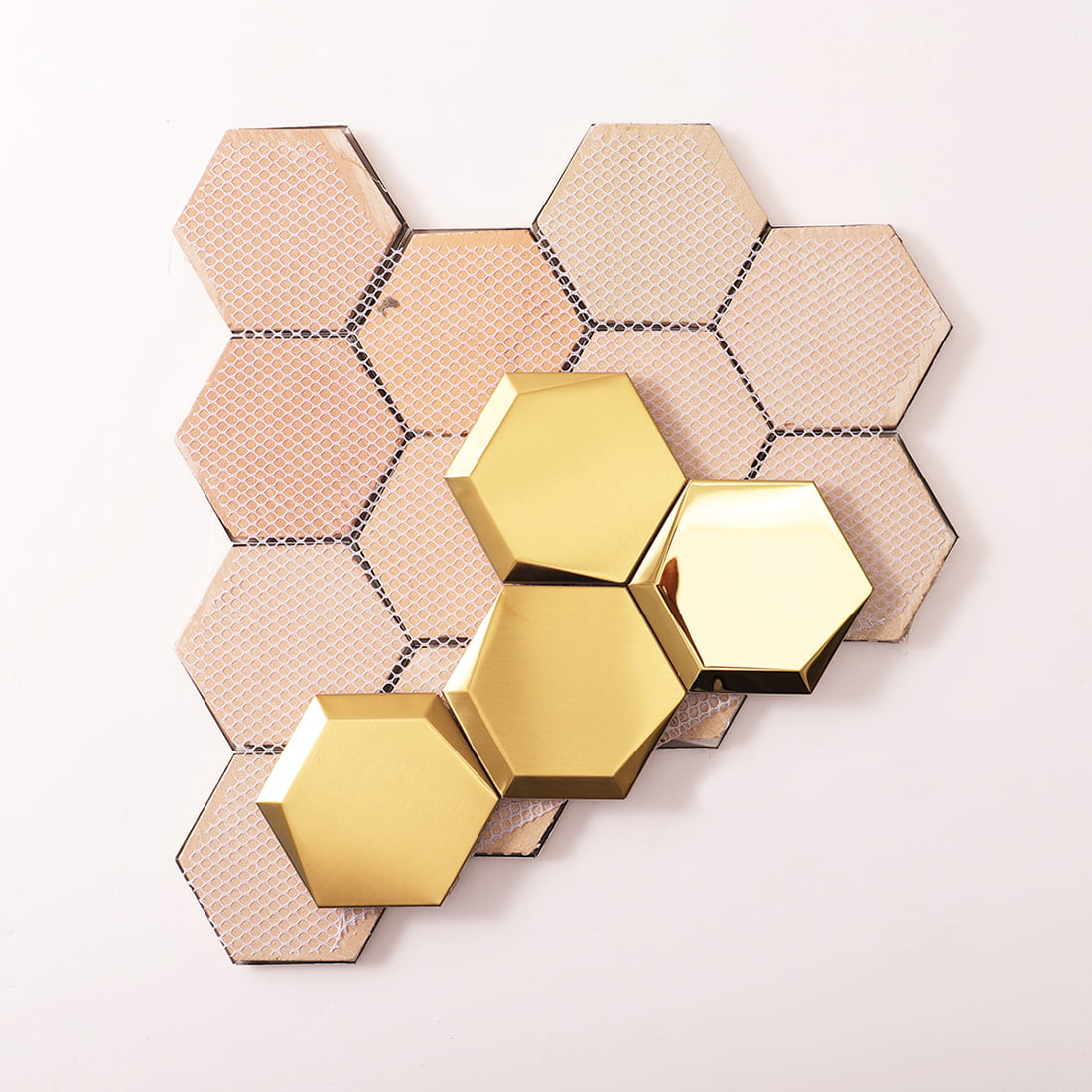 Front and back view of gold hexagon tiles showing the white mesh mounting.