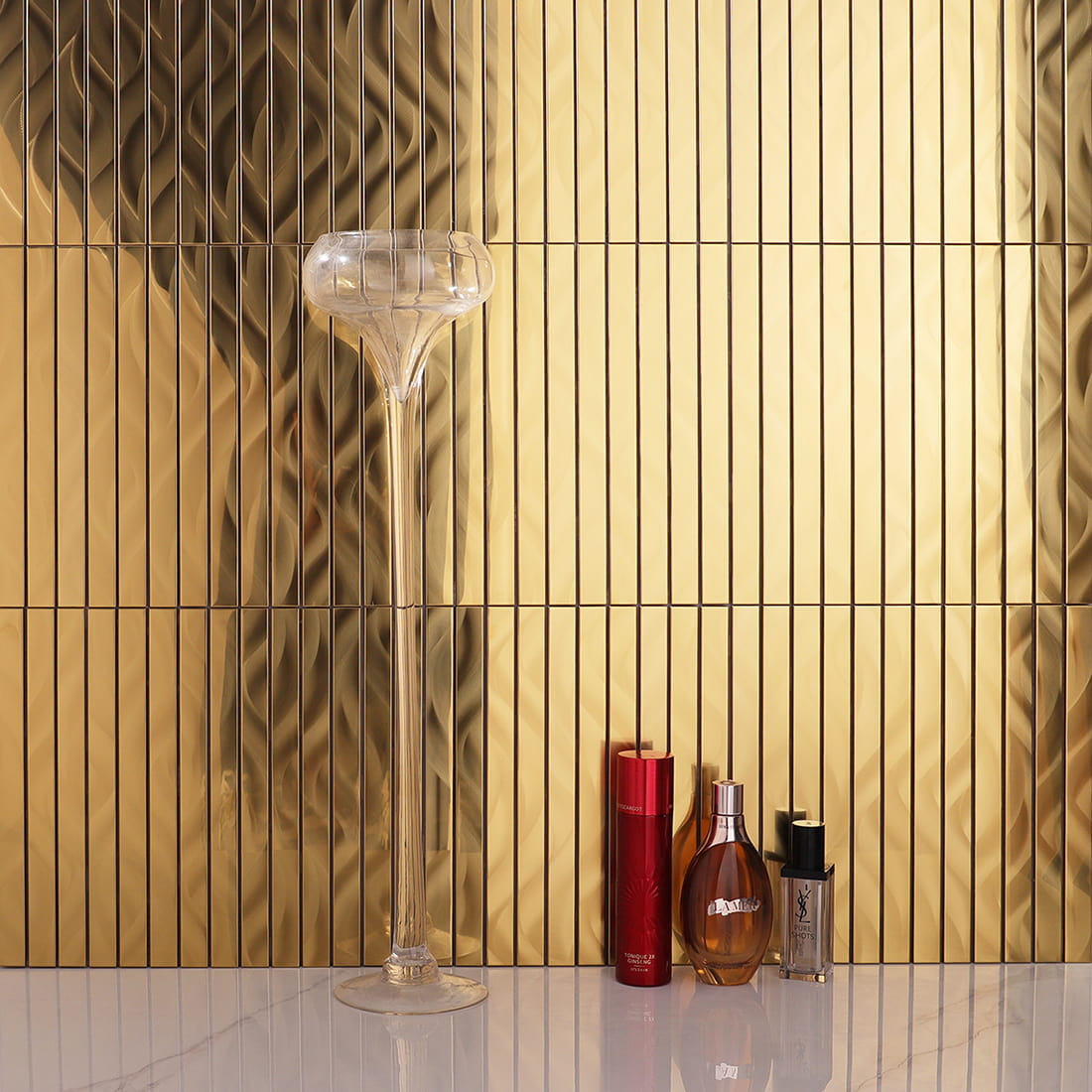 Gold linear metal mosaic tiles installed as a backsplash behind decor.