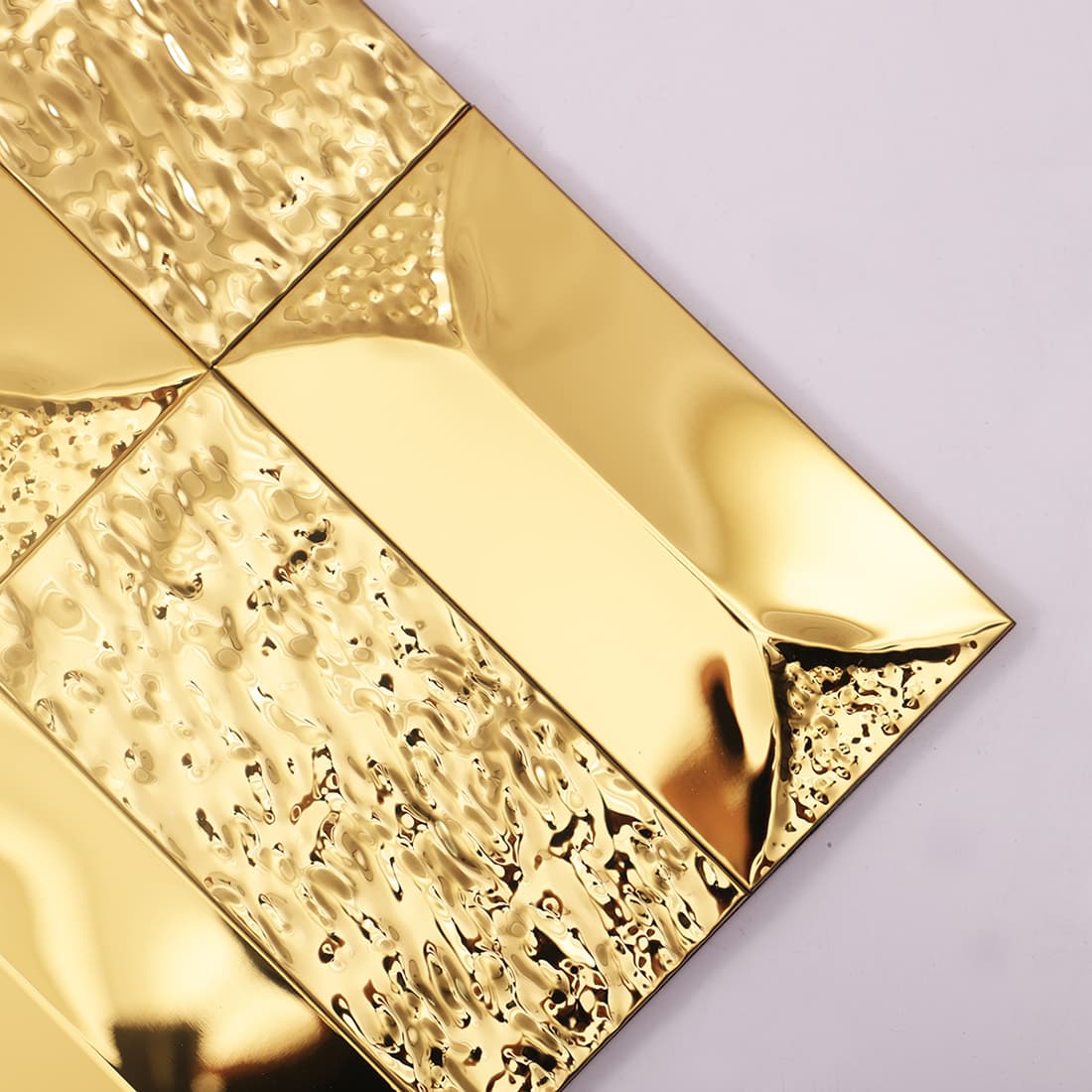 Detailed macro close-up of the hammered and polished surface texture of a gold tile.