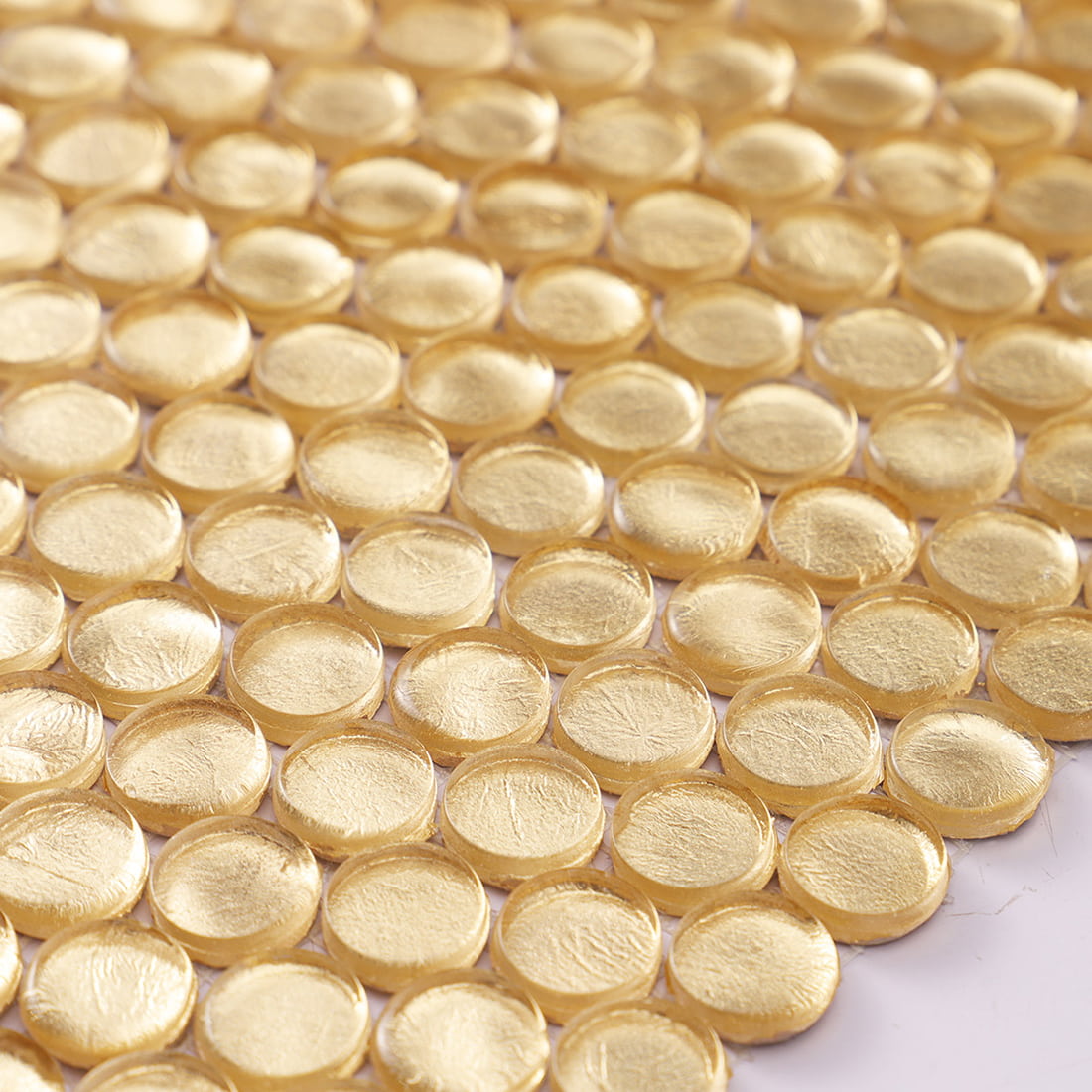 Surface texture of gold penny round glass mosaic tiles