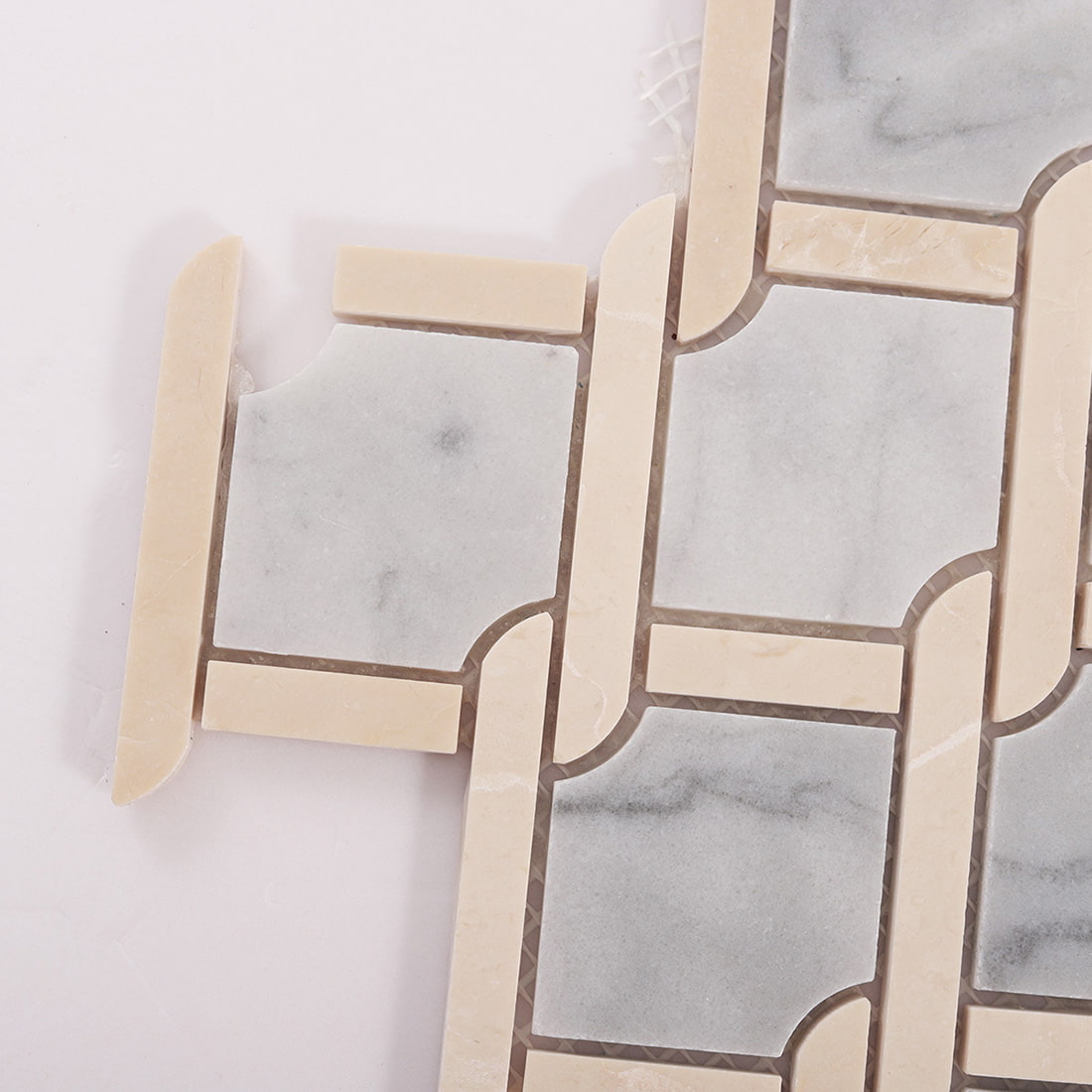 Close up of gray marble and beige chain link mosaic tile corner detail