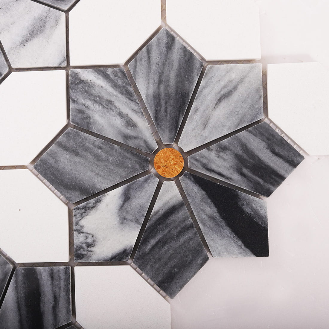 Close up top view of a gray marble flower mosaic with an amber center dot