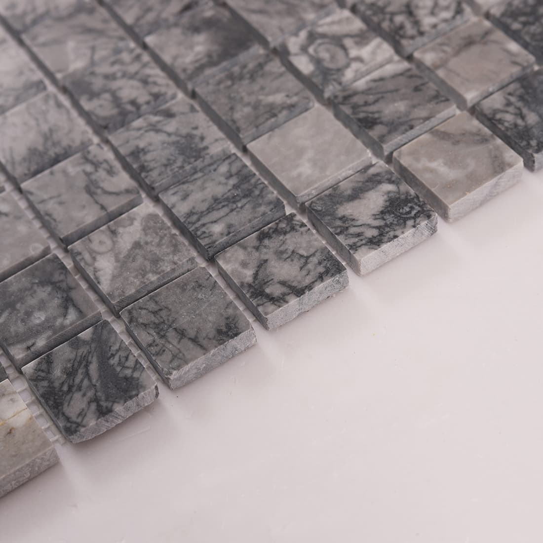 Side angle view showing thickness of gray marble square mosaic tiles