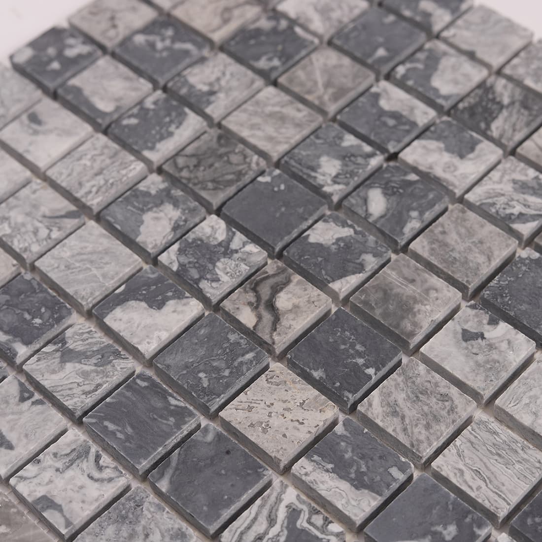 Angled surface view of gray marble square mosaic tiles showing depth and spacing