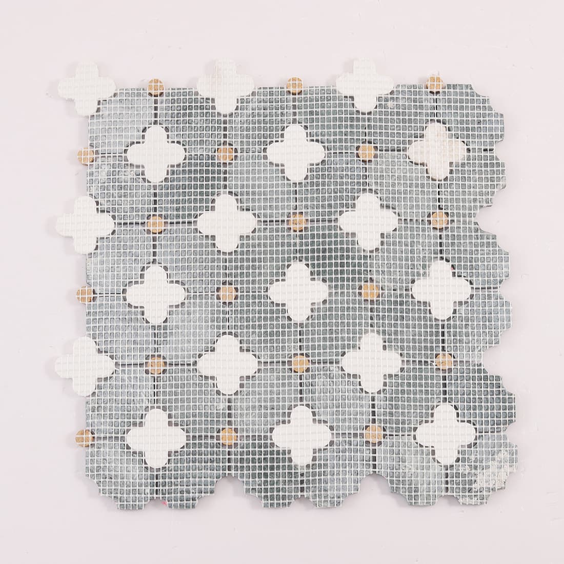 Back view of mosaic tile sheet showing mesh backing and clover cutouts