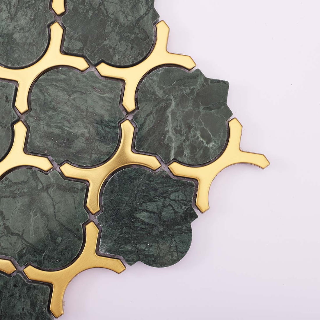 Close-up of green marble mosaic with brushed gold stainless steel trim
