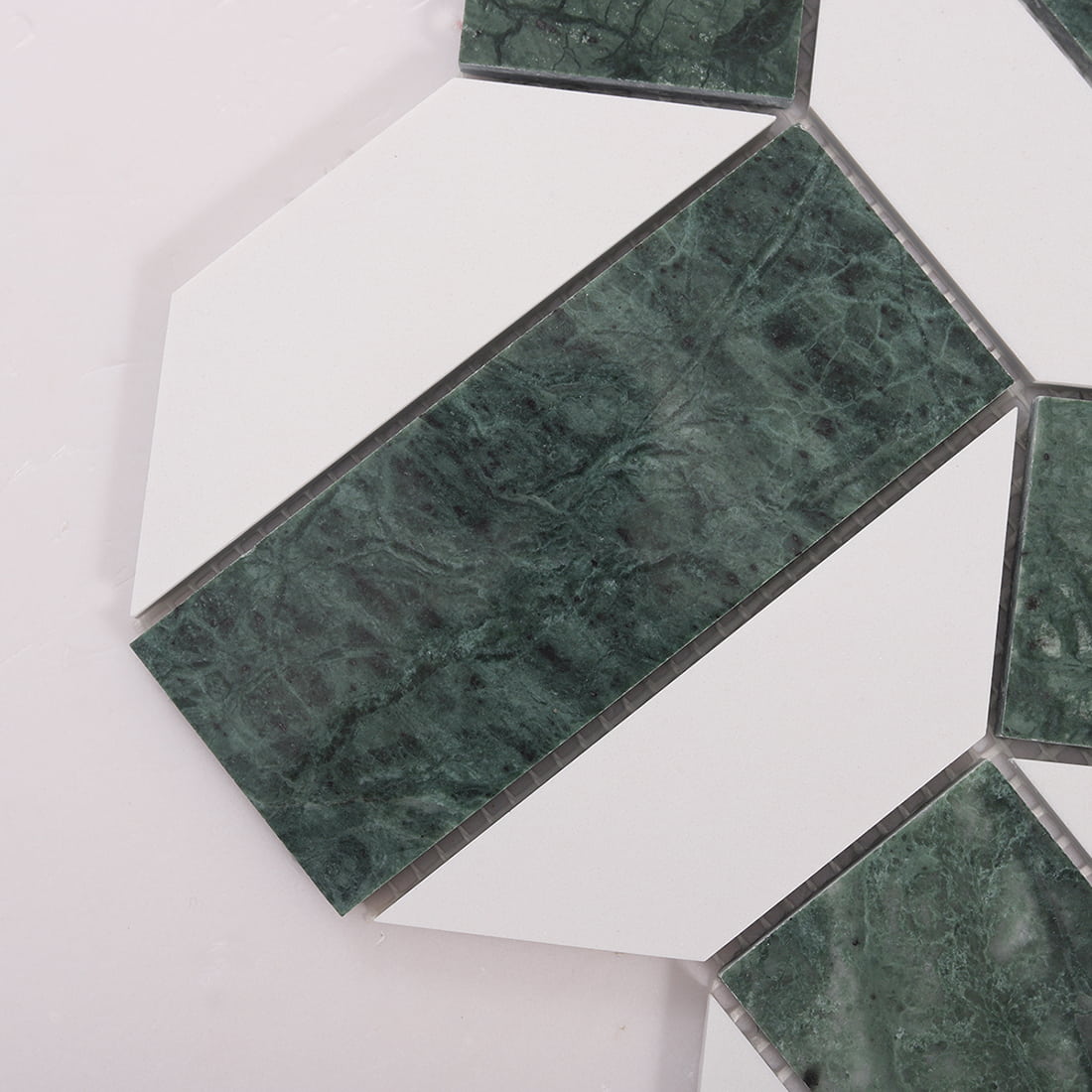 Close up of green marble rectangular insert with white marble pieces in geometric pattern