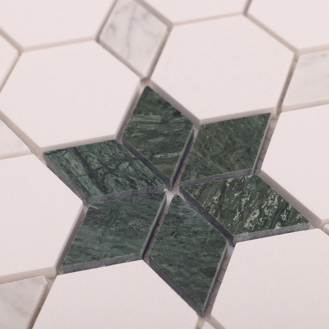 Macro close-up of green marble star inlay surrounded by white hexagon tiles.