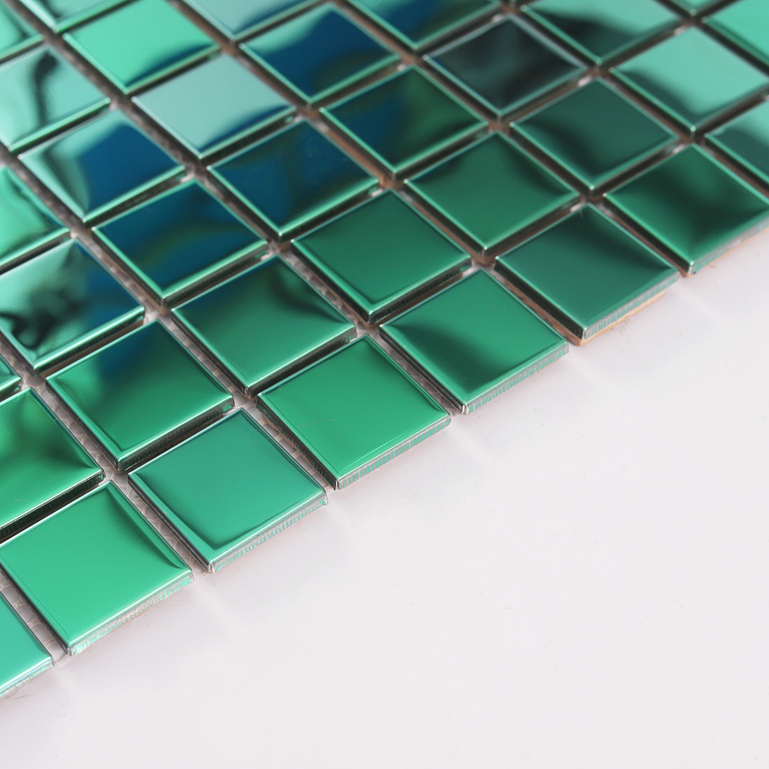 Edge detail of green stainless steel mosaic tile with square metal chips