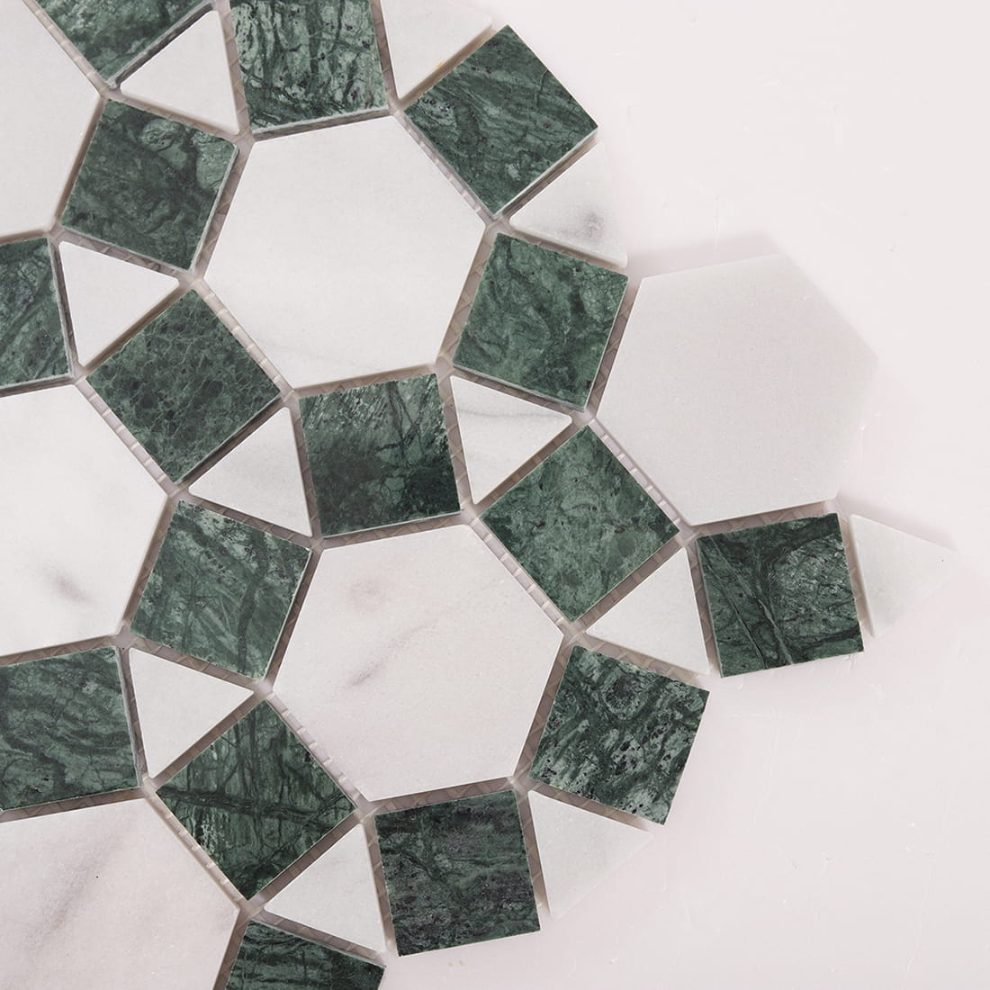 Close up of green stone squares and white hexagons with grout joints