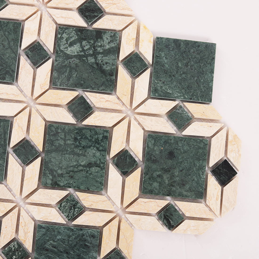 Close up detail showing the pattern of green and beige marble flower mosaic tile