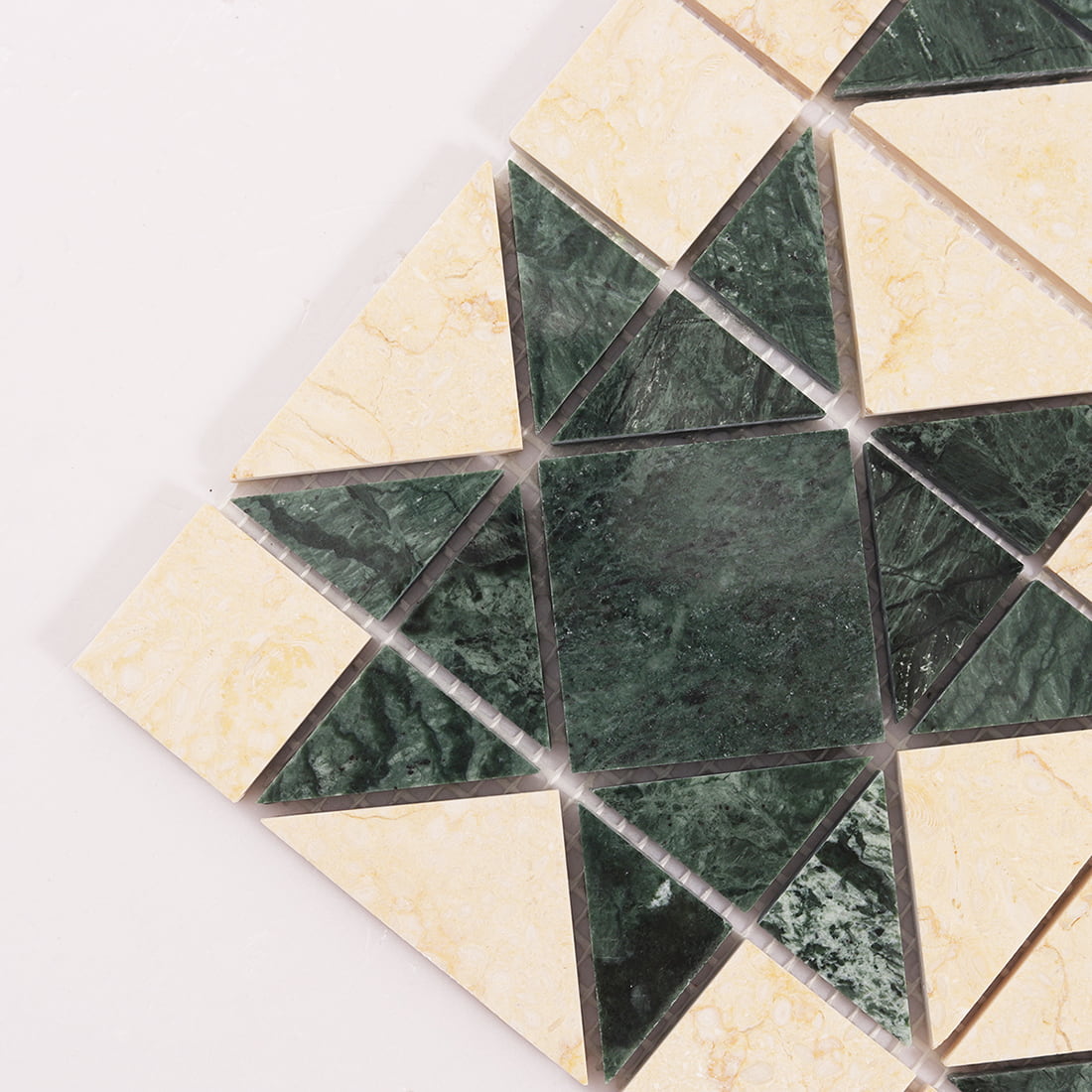 Close up of green and cream marble mosaic tile corner with triangle and square pieces