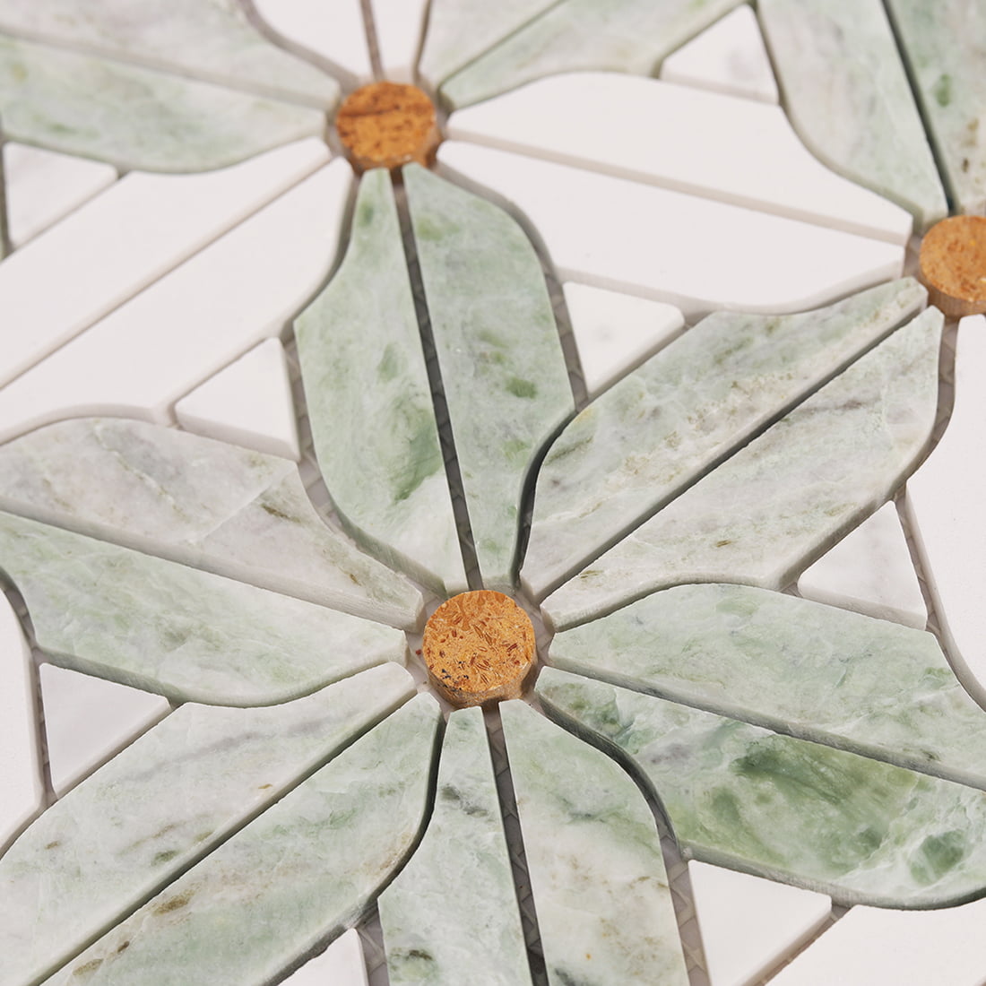 Close up of a single windmill flower motif in green and white marble with round center accent