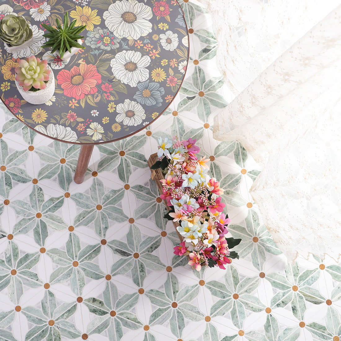 Top view of installed green and white windmill flower mosaic floor beside a round table