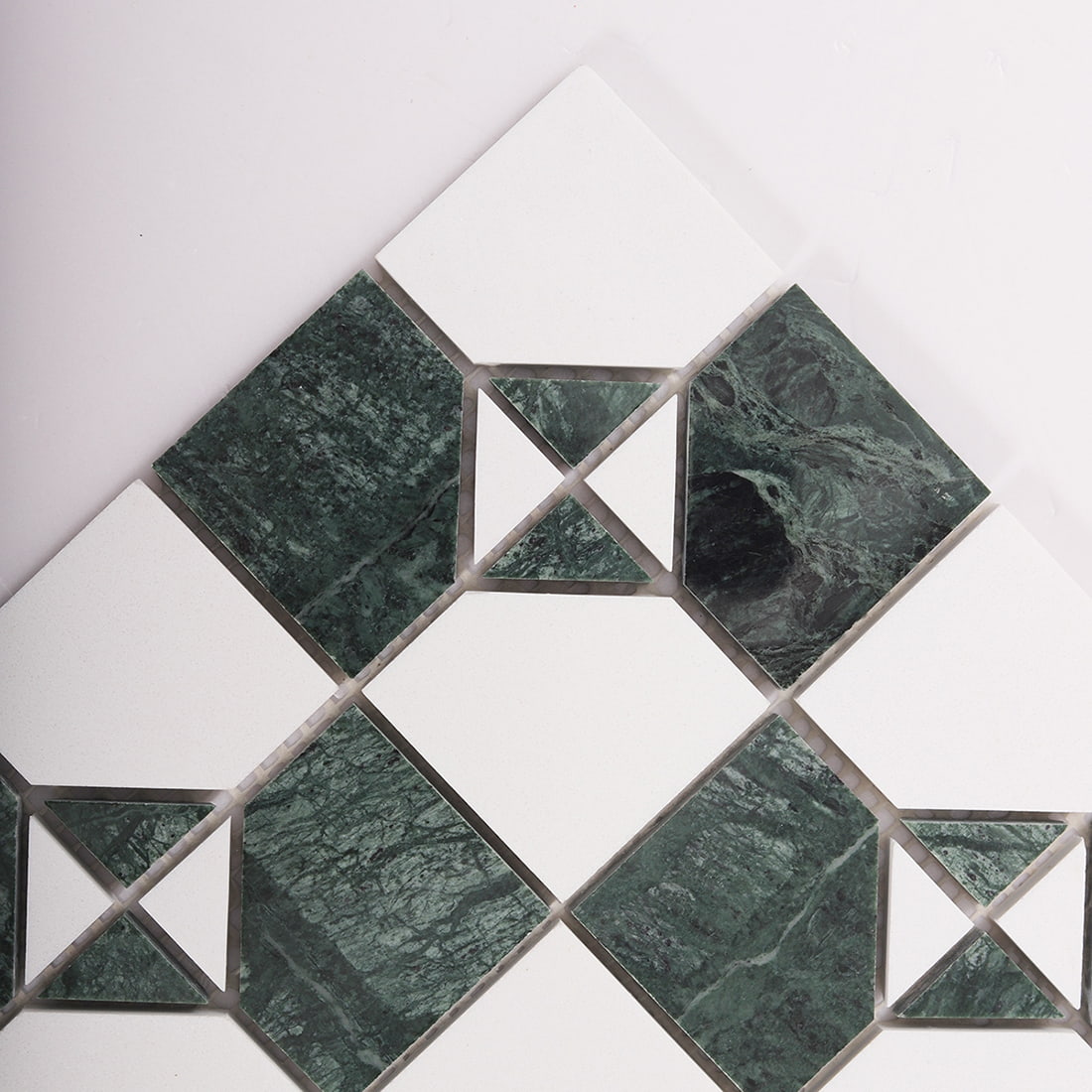 Angled close up of green marble and white square mosaic showing corner details