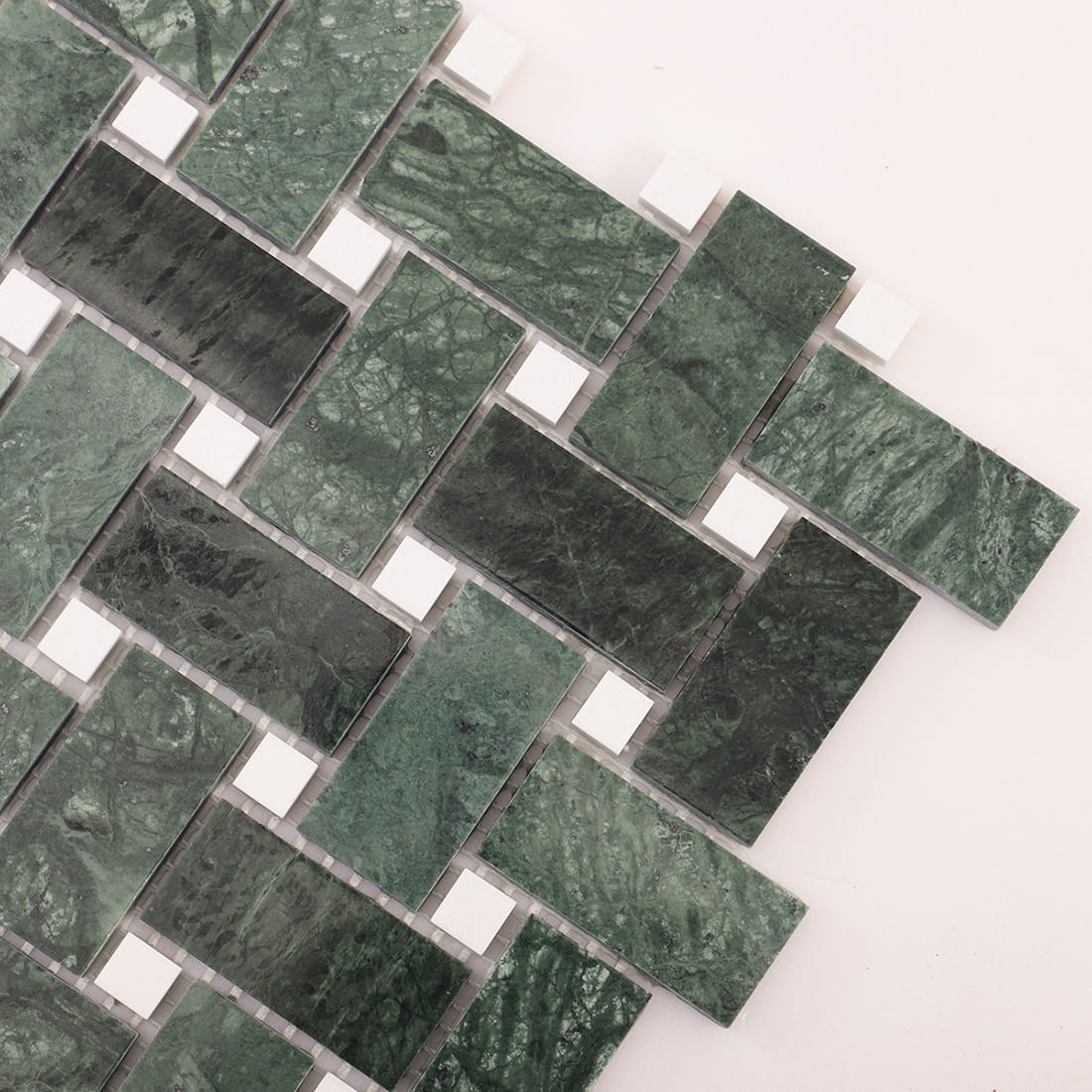 Diagonal close-up of green marble basketweave mosaic with white square dots