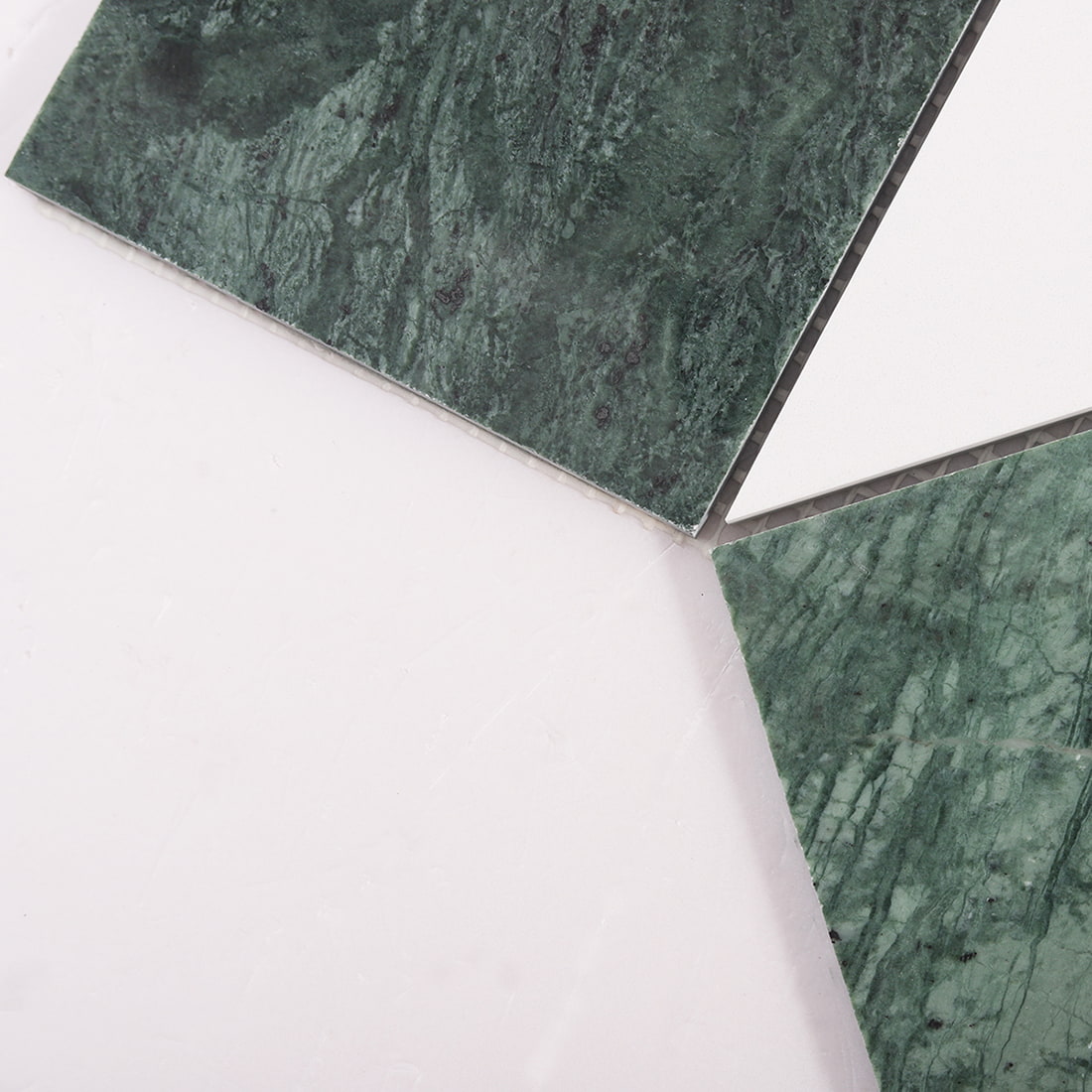Close up of green marble and white tile corners showing joints and edges