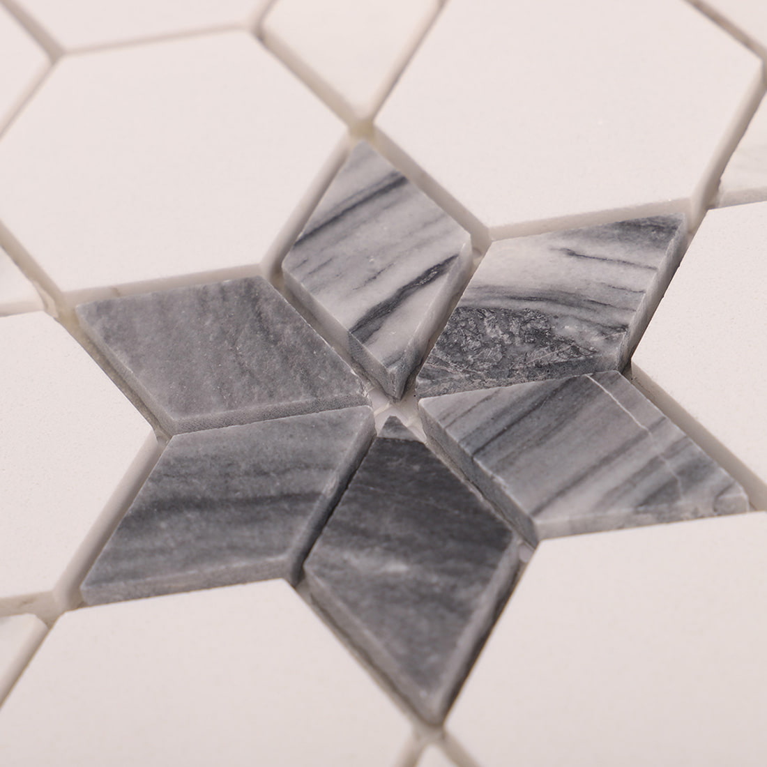Close-up of white hexagon mosaic pattern featuring grey star inlay accents.