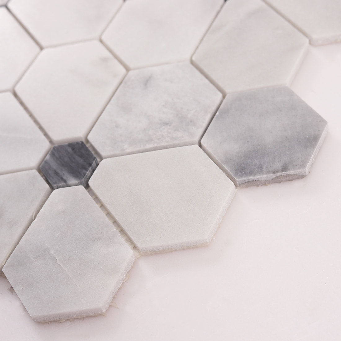 Corner detail of white hexagon marble mosaic with gray accent pieces