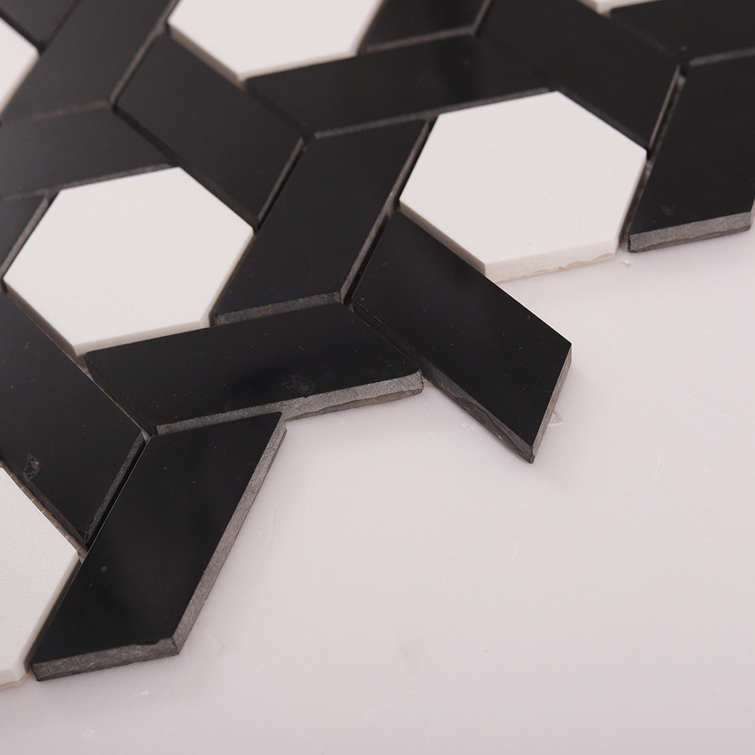 Close up showing edge thickness of black and white mosaic tile pieces