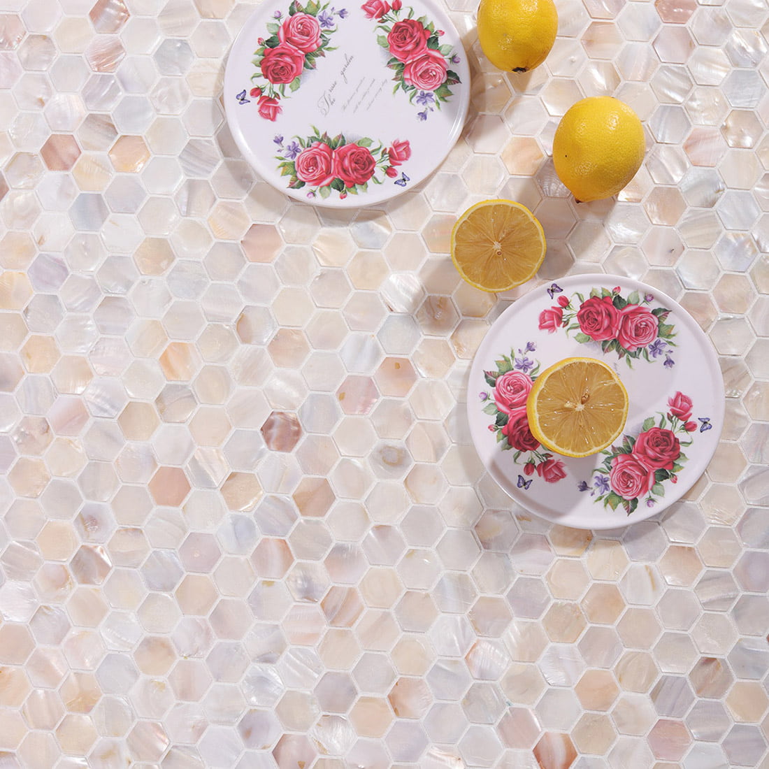 Styled scene of hexagon mosaic tile with floral plates and lemons