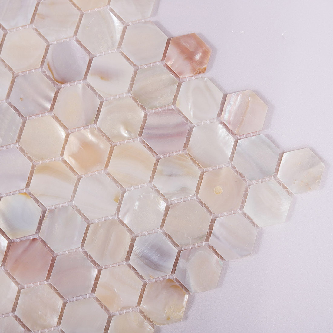 Closeup of hexagon shell mosaic tile corner showing iridescent pieces