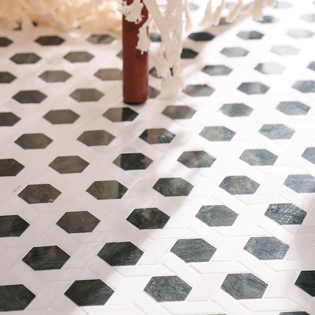 Close view of green hexagon mosaic floor with chair leg, showing real space effect