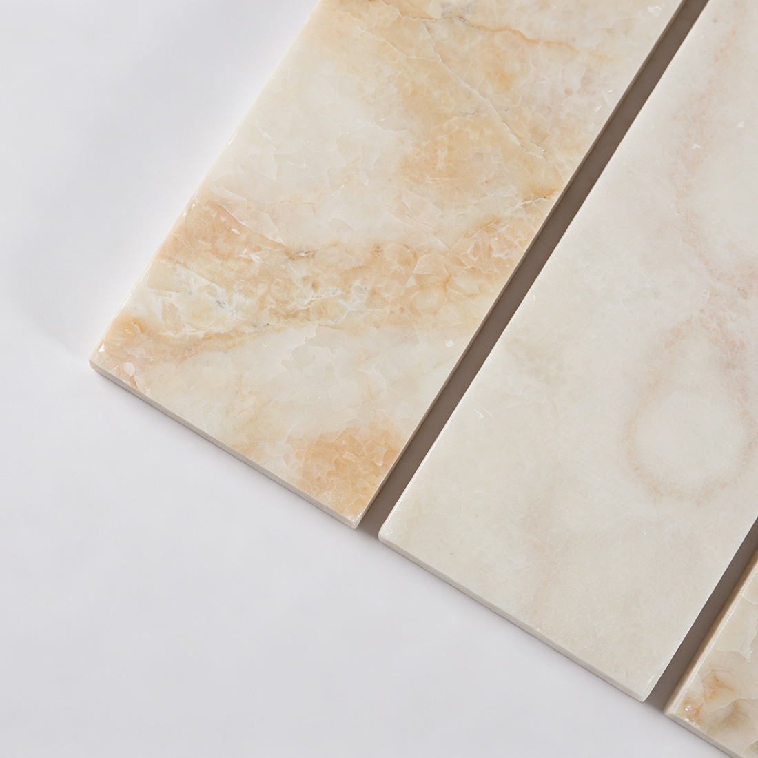 Close-up of ivory onyx wide bar mosaic tile with translucent natural texture