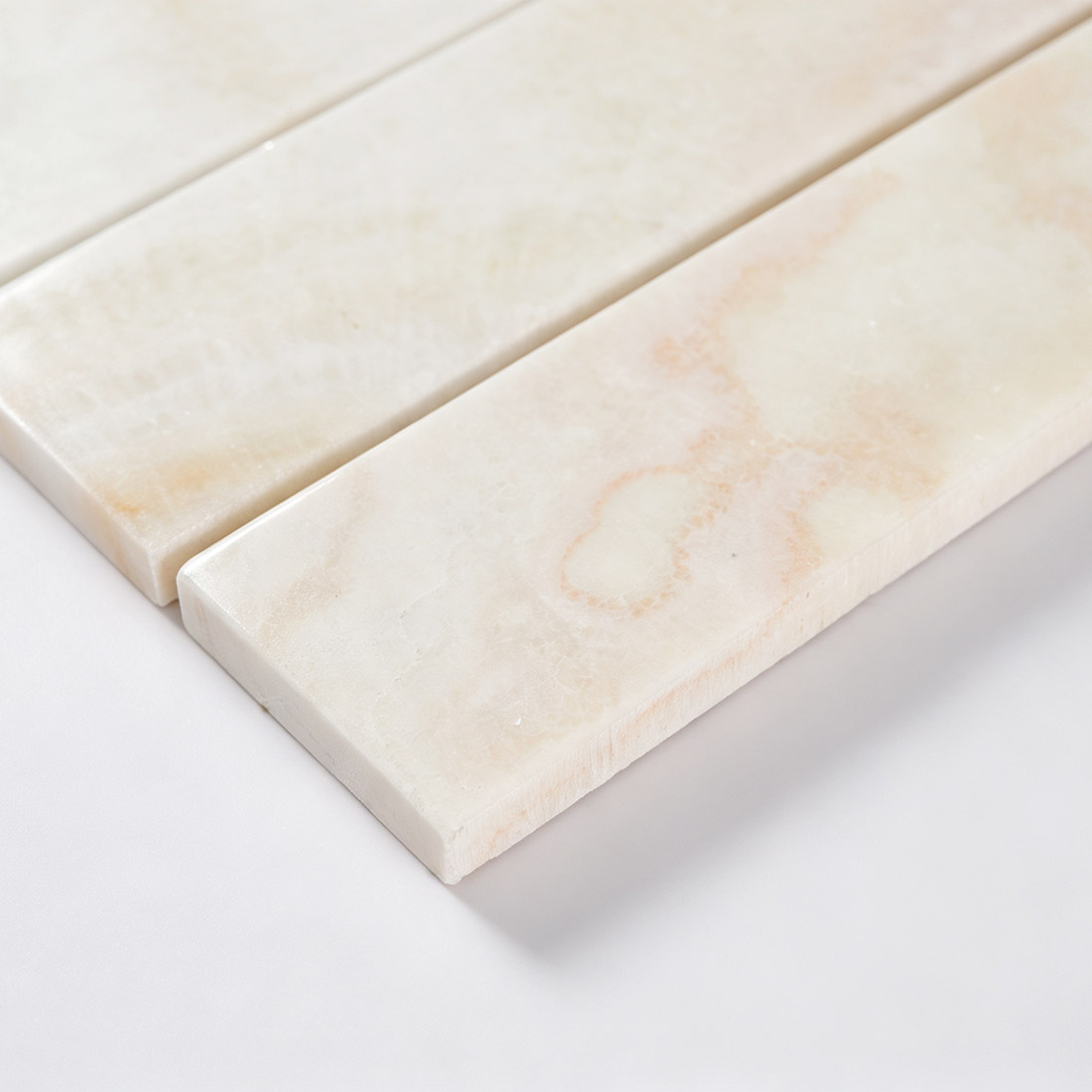 Close-up showing ivory onyx wide bar mosaic tile thickness and edges