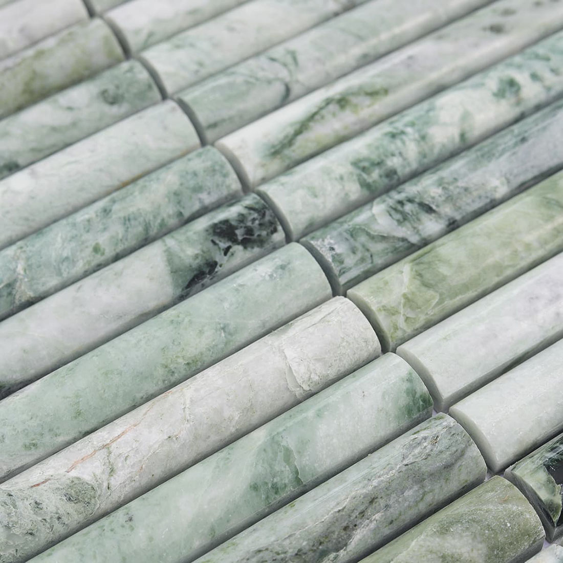 Jade green marble mosaic strips with rounded surfaces and varied veining