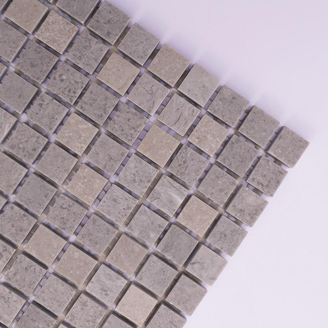 Corner detail of light gray square marble mosaic tile with natural veining