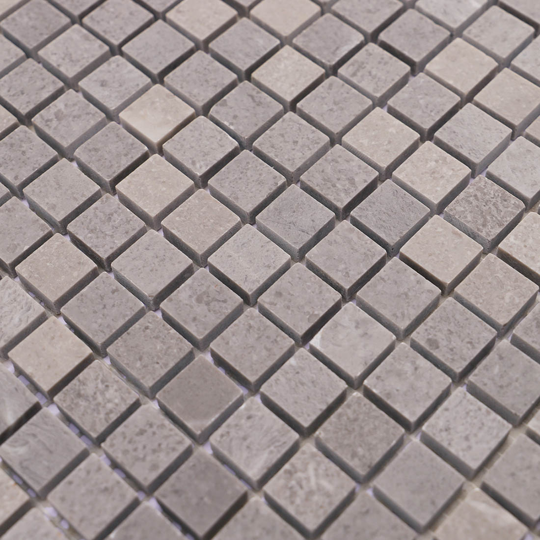 Close-up of light gray square marble mosaic tiles with subtle stone variation