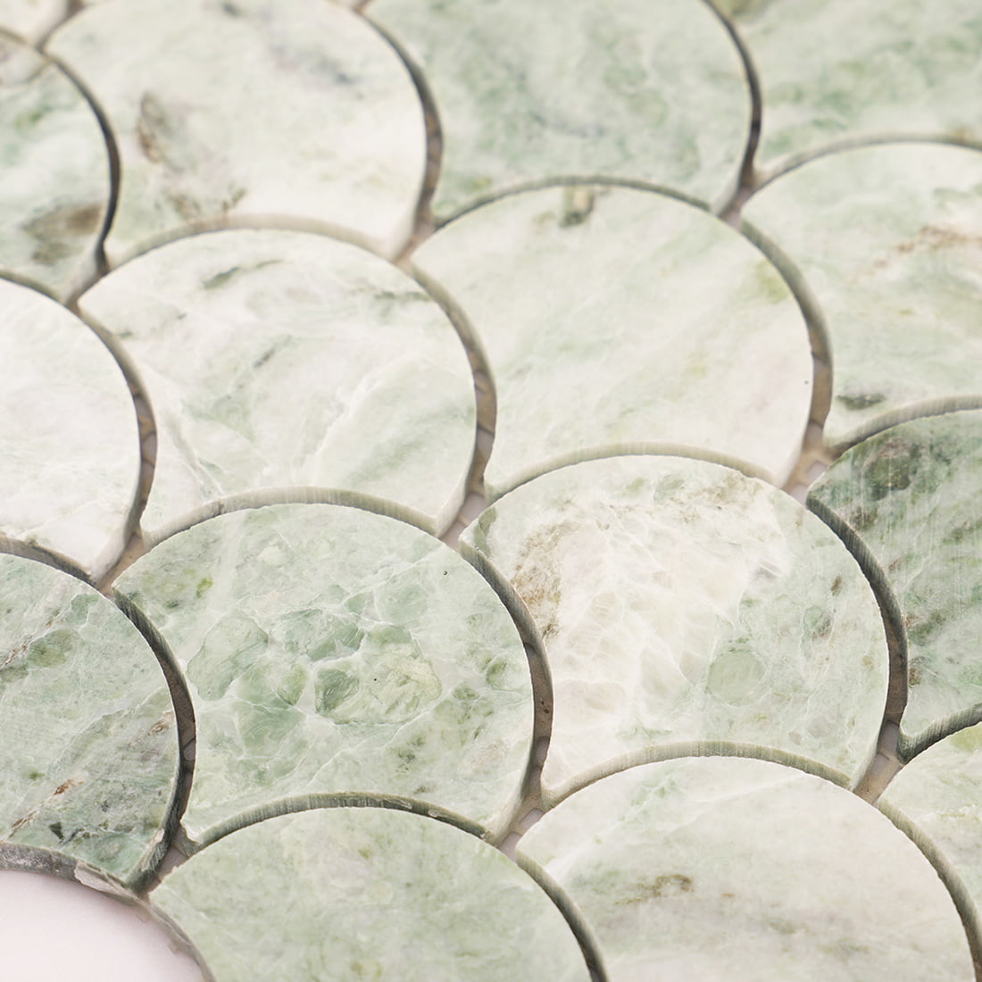 Close up of light green marble fish scale mosaic tiles highlighting texture and edges