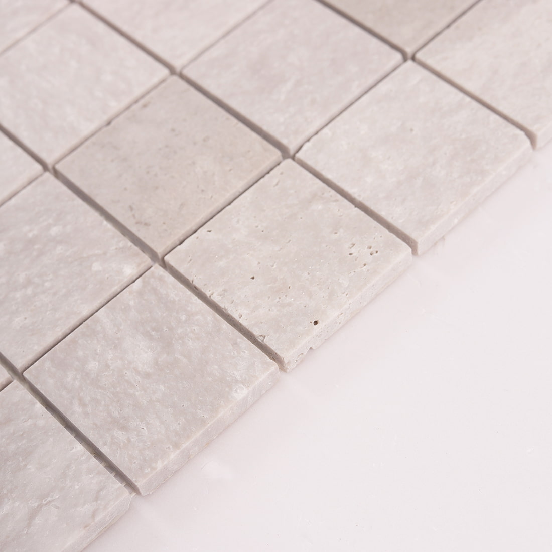 Side angle view showing thickness of light gray marble square mosaic tiles
