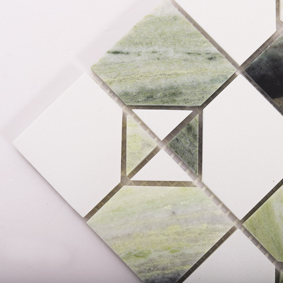 Angled close up of light green marble and white square mosaic showing corner details