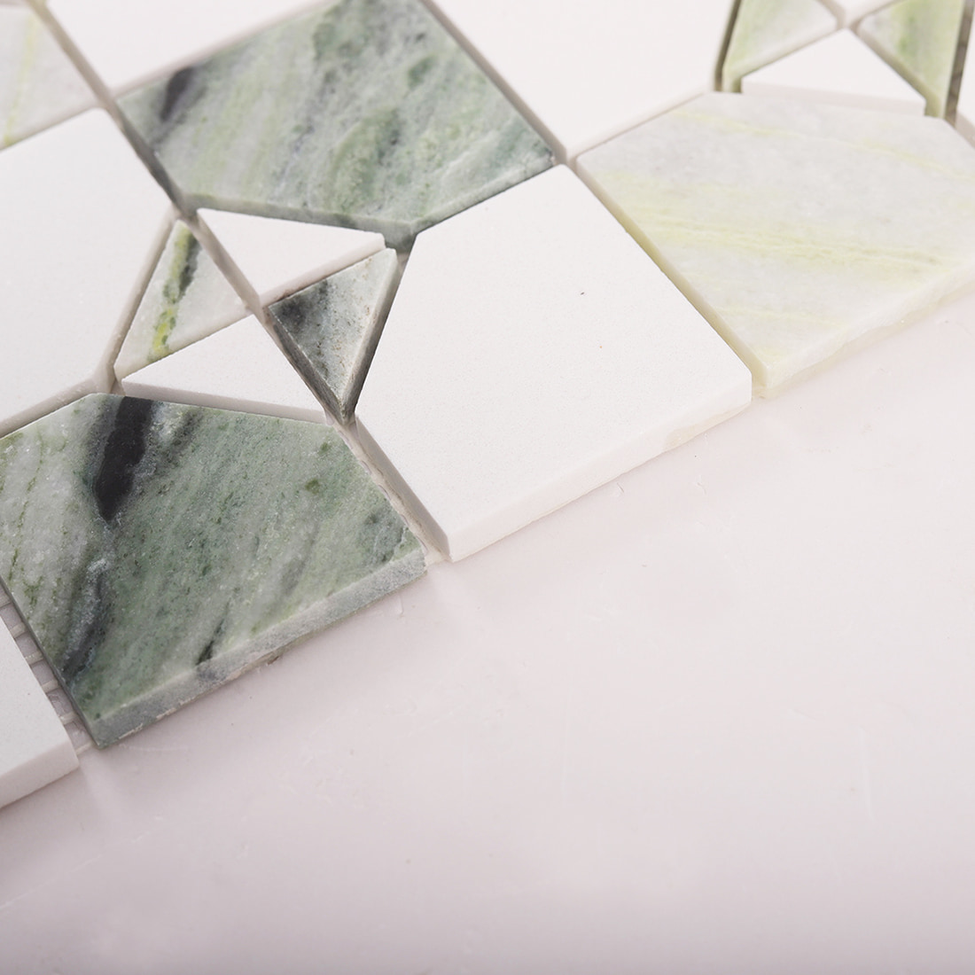 Close up of tile edge thickness on light green marble and white square mosaic sheet