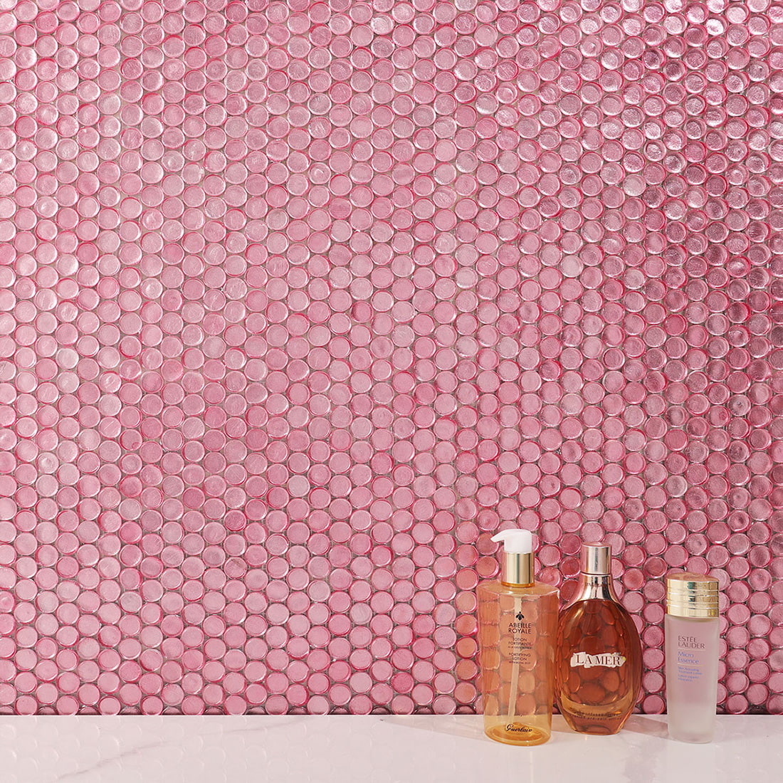 Light pink penny round glass mosaic tiles installed on bathroom wall