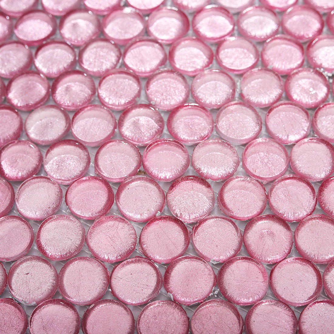 Surface detail of light pink round glass mosaic tiles with subtle shimmer