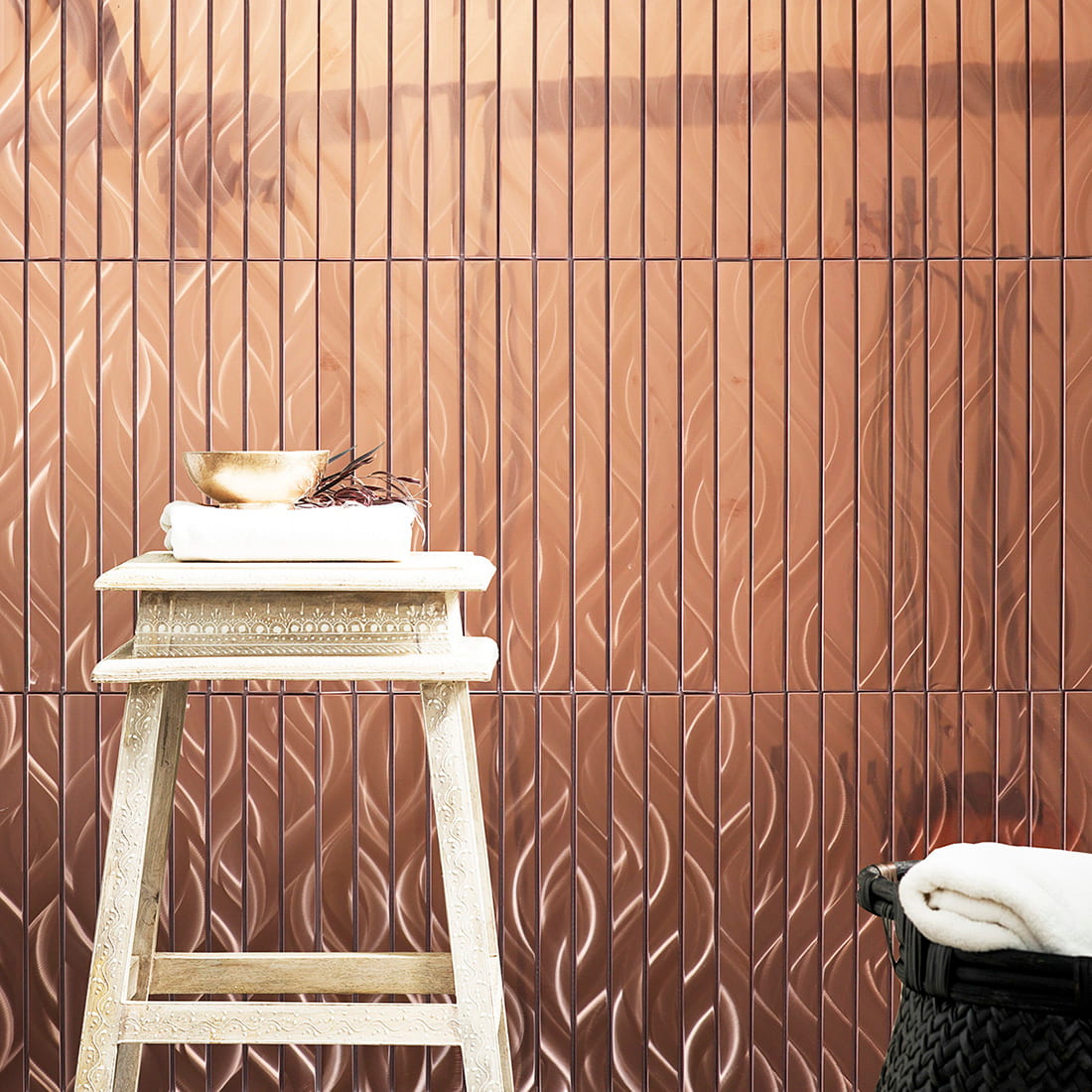 Luxury wall decor featuring rose gold linear metal mosaic tiles in a room setting.