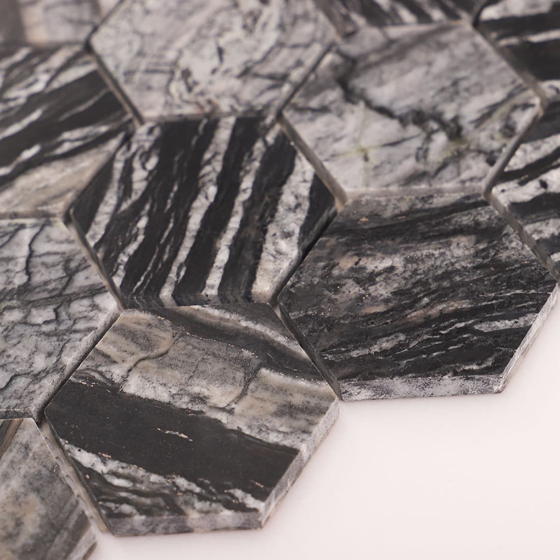 Macro shot of marble hexagon tiles showing beveled edges and thickness.