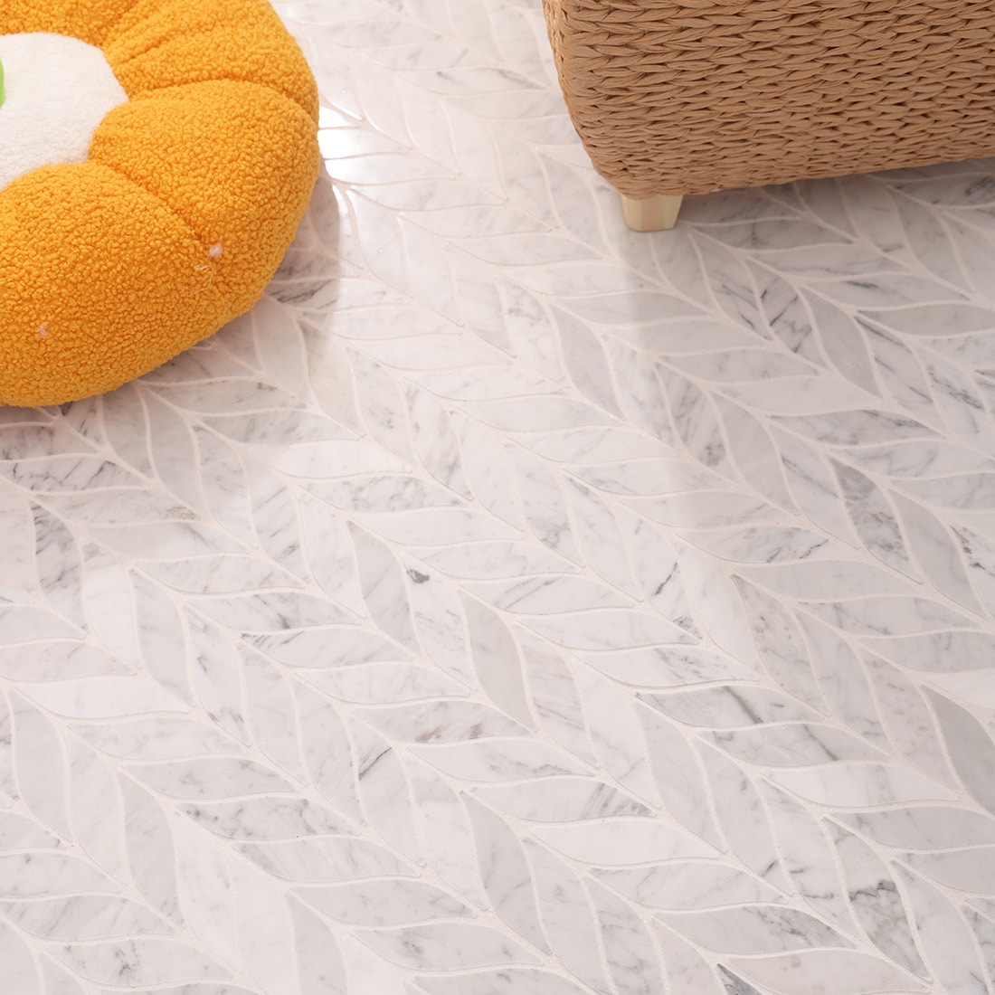 Installed marble leaf mosaic surface next to orange cushion and woven basket