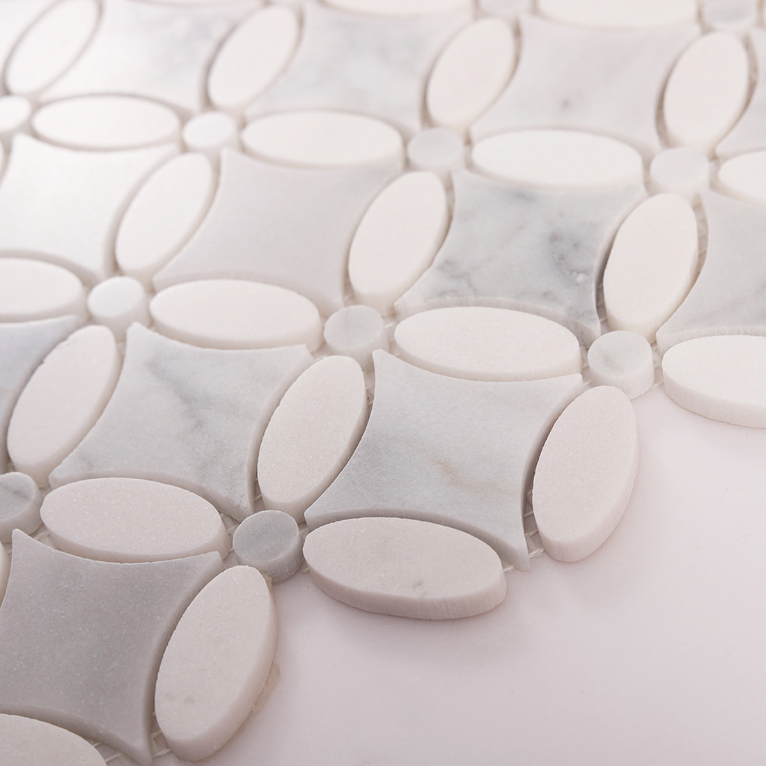 Angled close up of marble oval flower mosaic showing thickness and finish