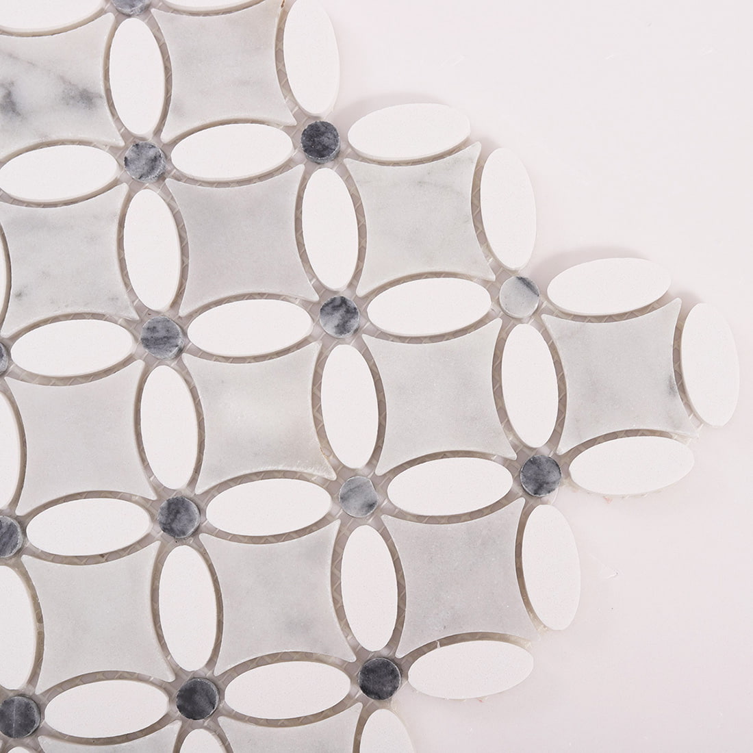 Close up of marble and white oval mosaic tile corner detail