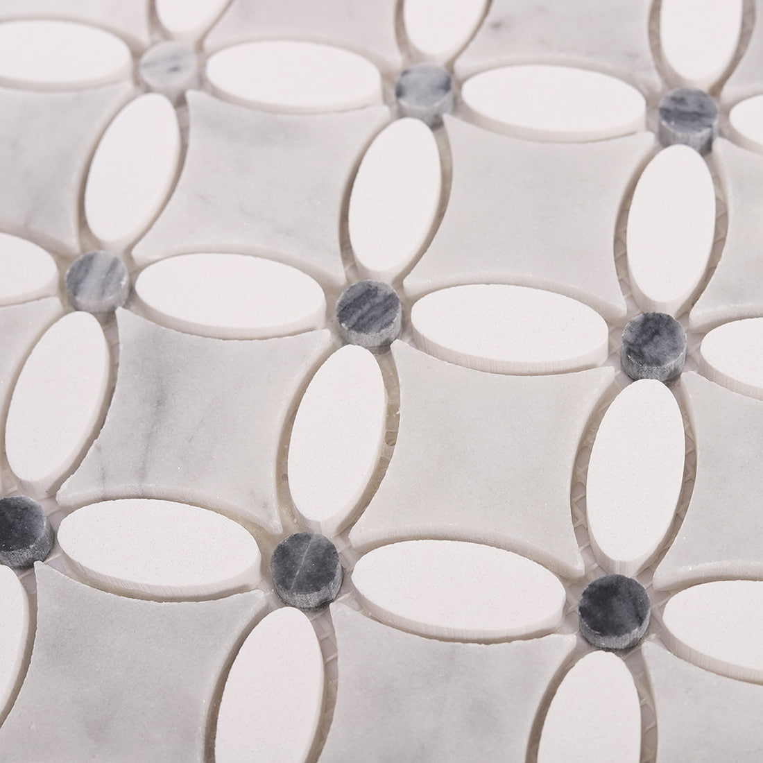 Angled close up showing 3D texture of marble and white oval mosaic tiles