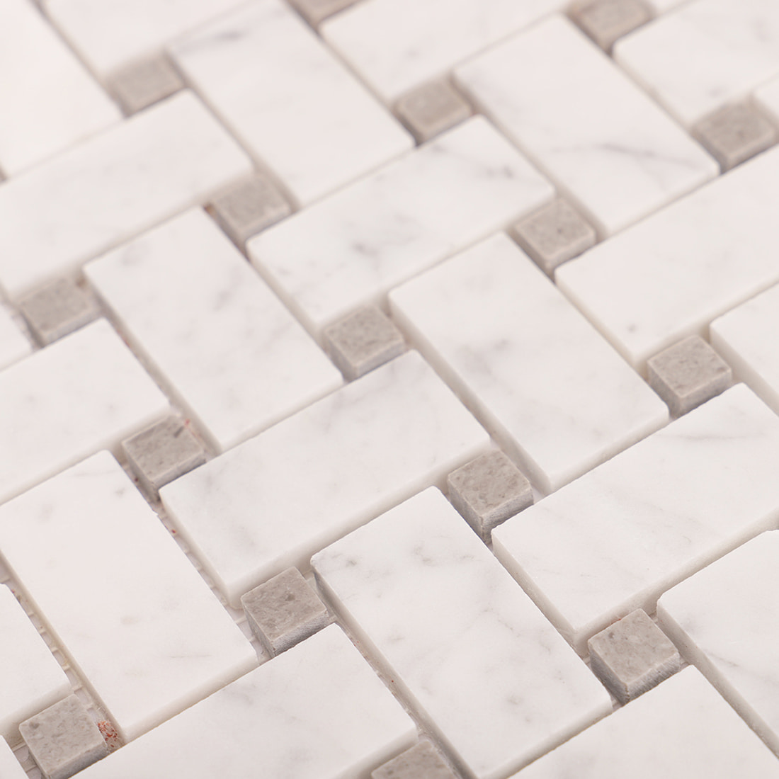 Texture close-up of white marble basketweave mosaic tiles and gray inserts
