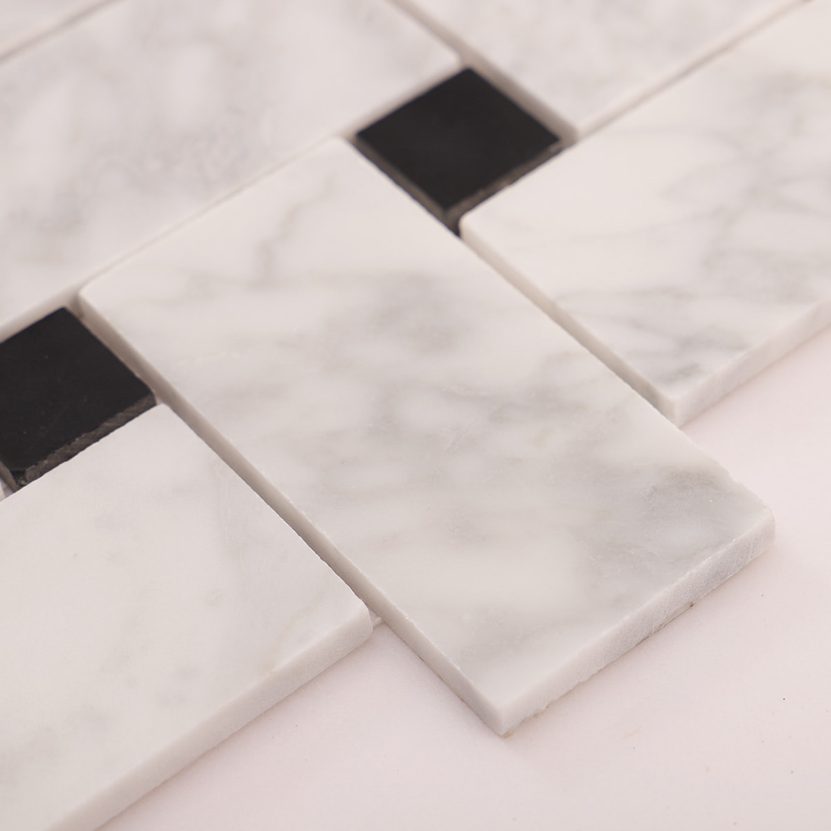 Close-up showing the edge thickness of a white marble mosaic tile piece.